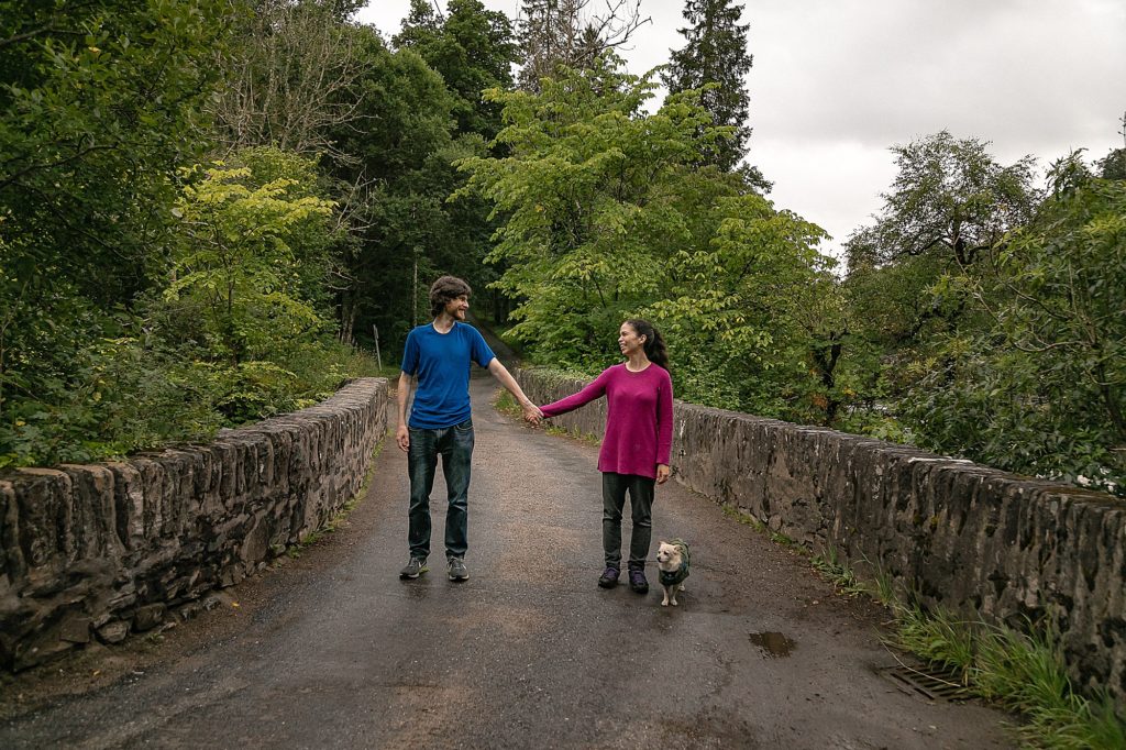 Couple on a bridge in Scotland with their dog