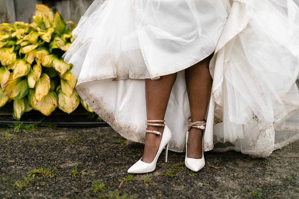 detail of brides heels and dirt covered wedding dress