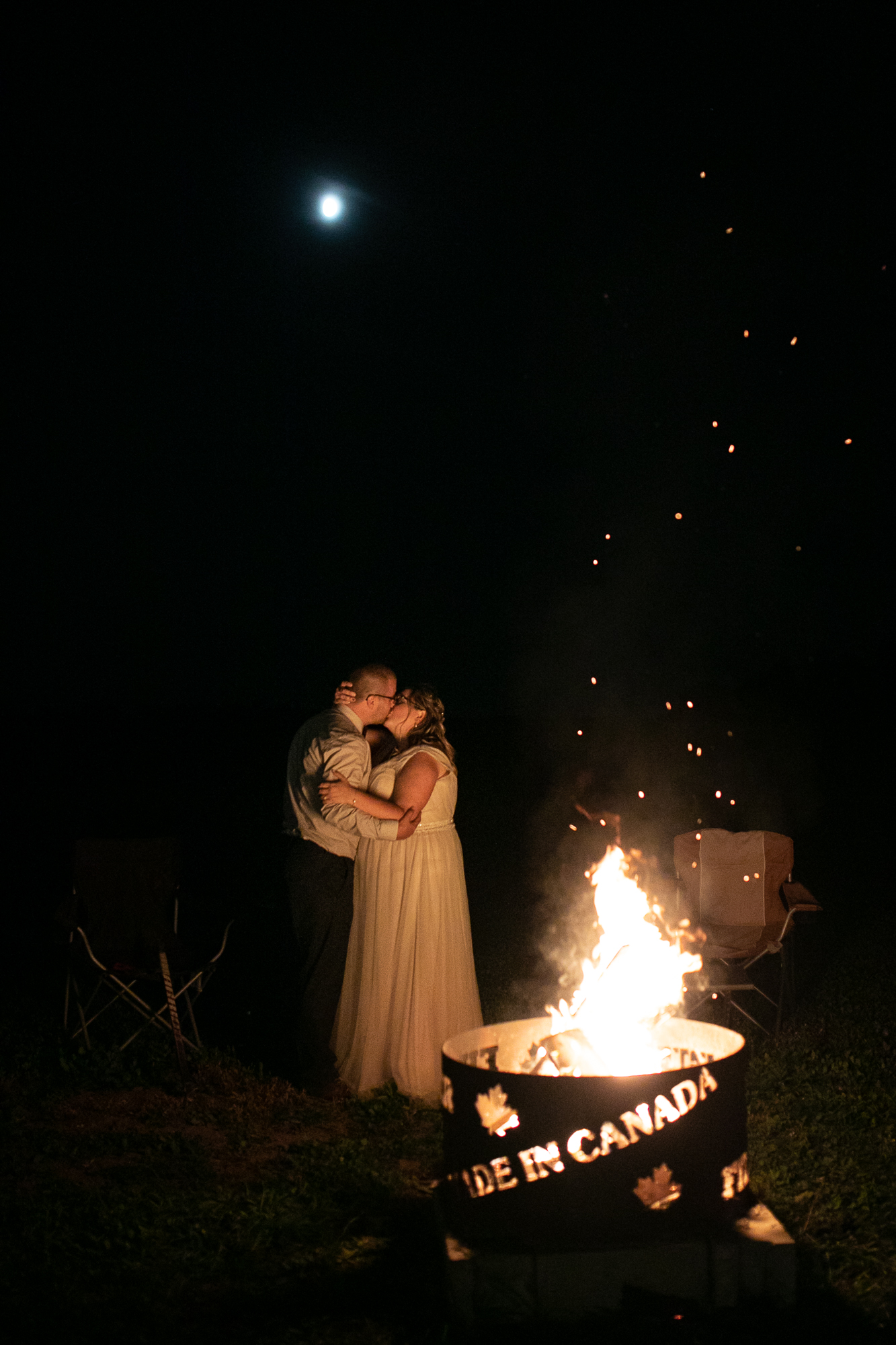 Couple kissing by a campfire