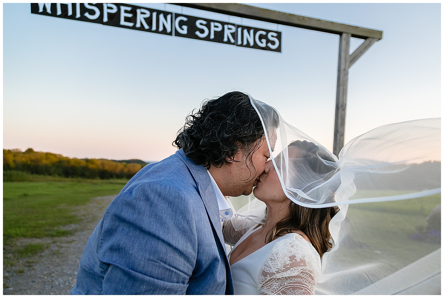 kissing by the whispering springs entrance at sunset